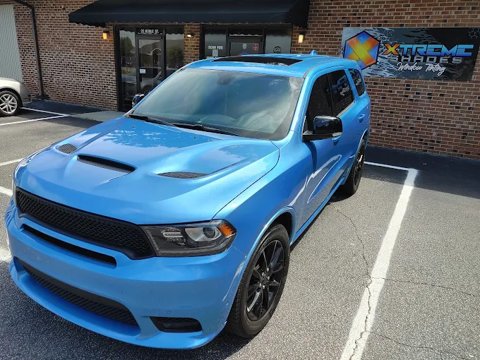 Blue Dodge Durango R/T with ceramic window tint outside the Xtreme Shades storefront